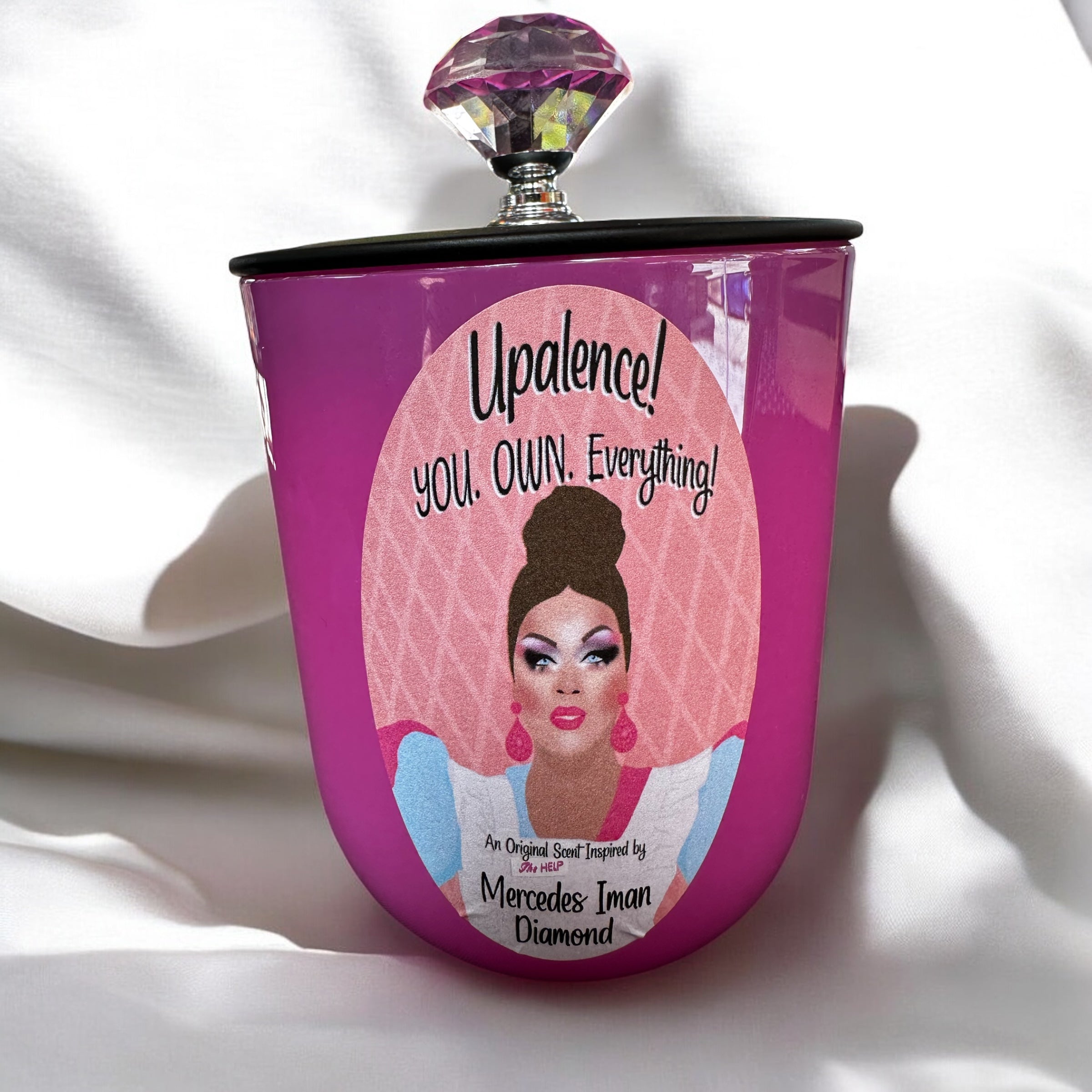 Pink candle featuring Mercedes Iman Diamond and text on a white background