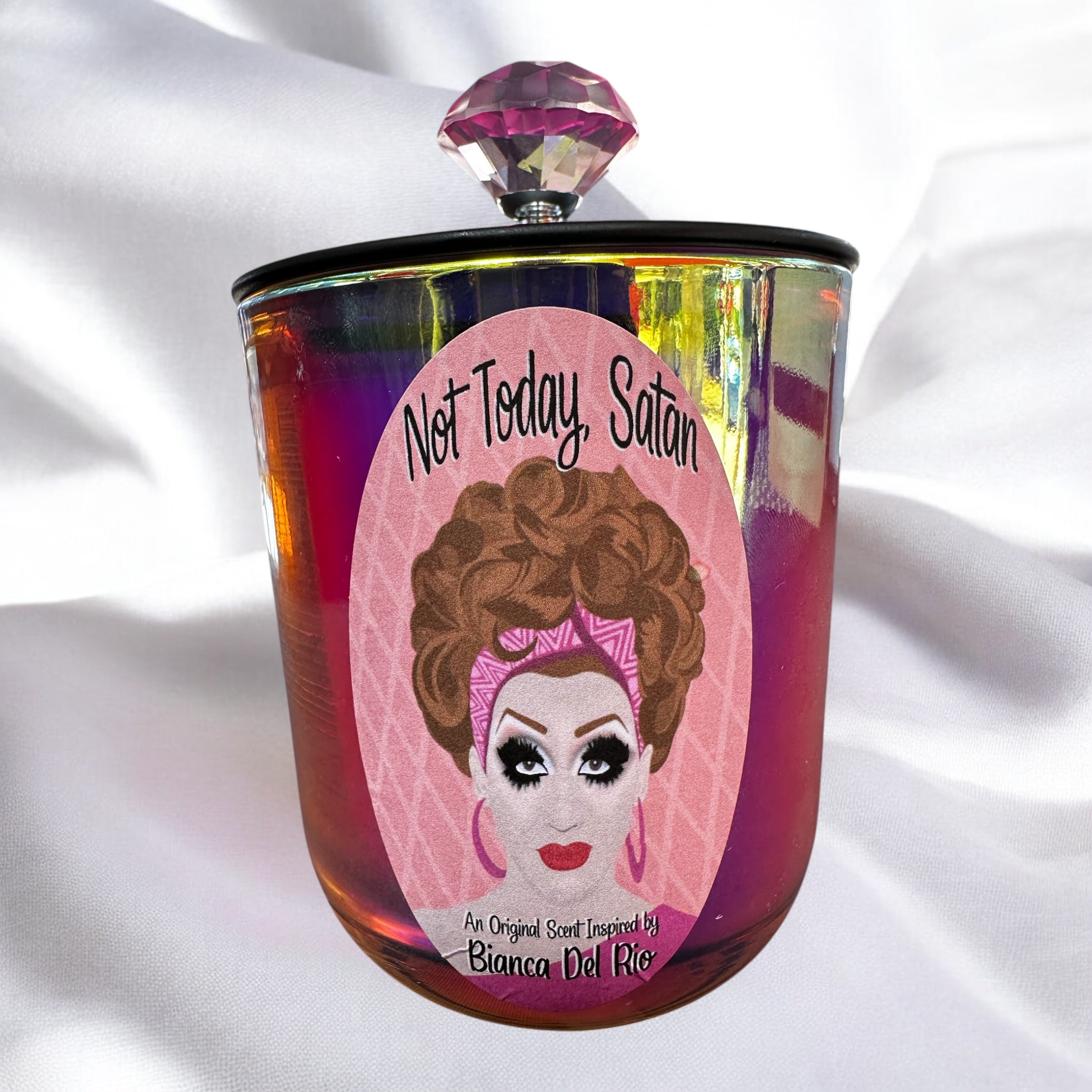 Candle with a design of Bianca DelRio and 'Not Today, Satan' text on a white fabric background