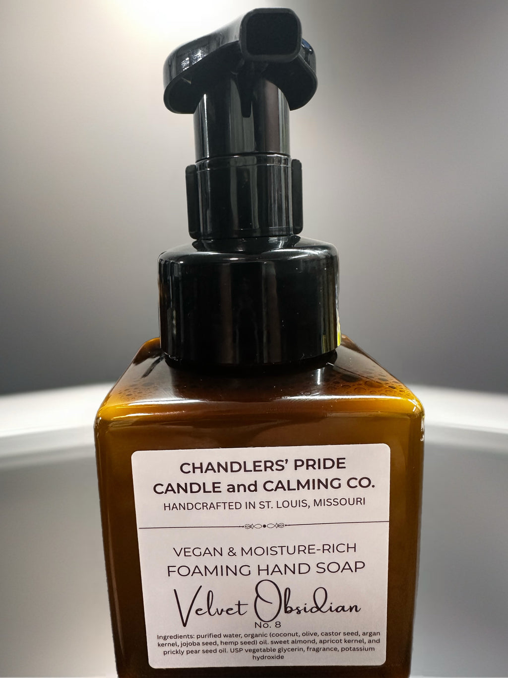 Brown bottle of Chandlers' Pride Candle and Calming Co. moisture-rich foaming hand soap with a pump on a neutral background.