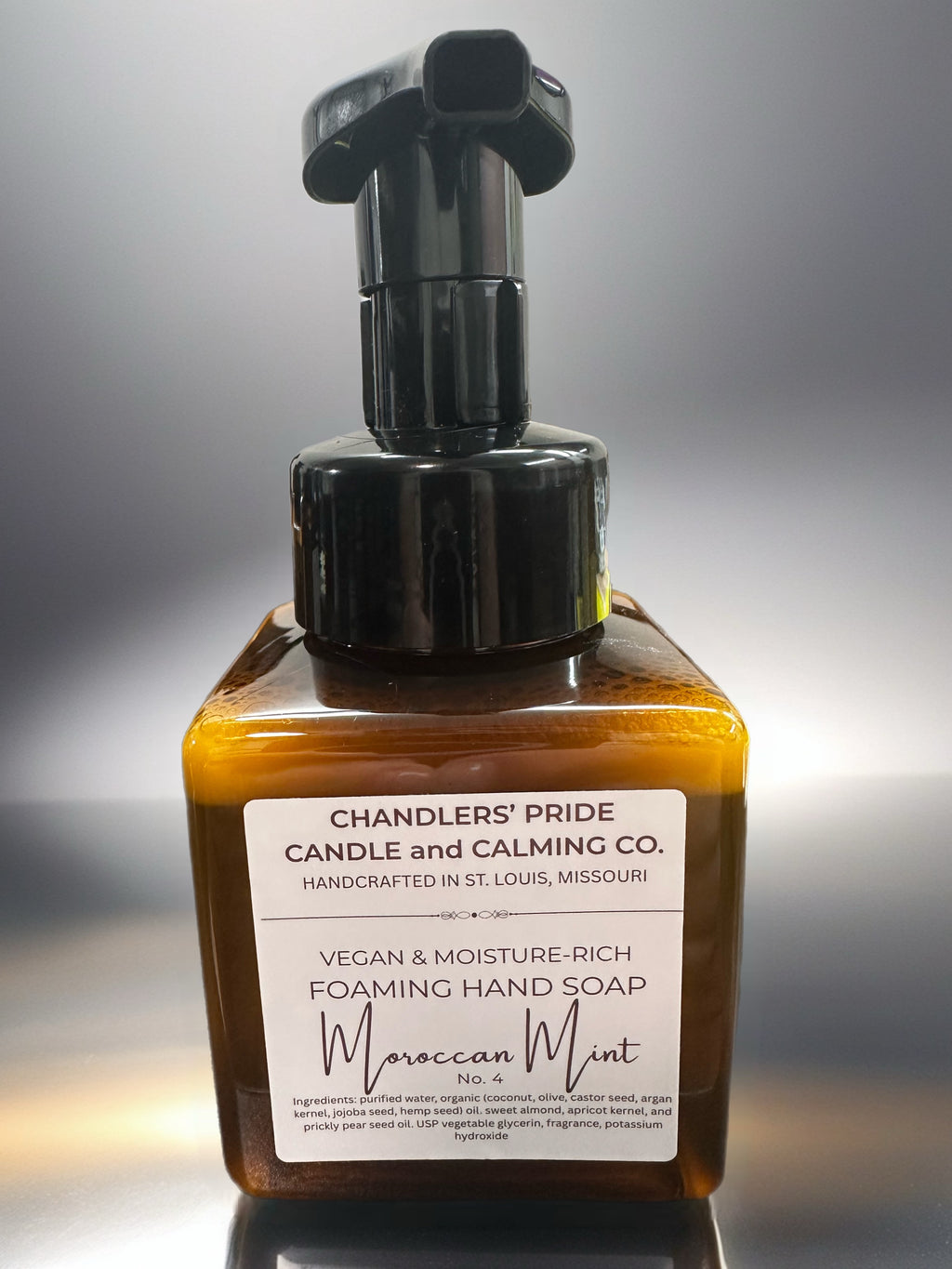 Brown bottle of Chandlers' Pride Moisture-Rich Foaming Hand Soap with a pump on a gray background