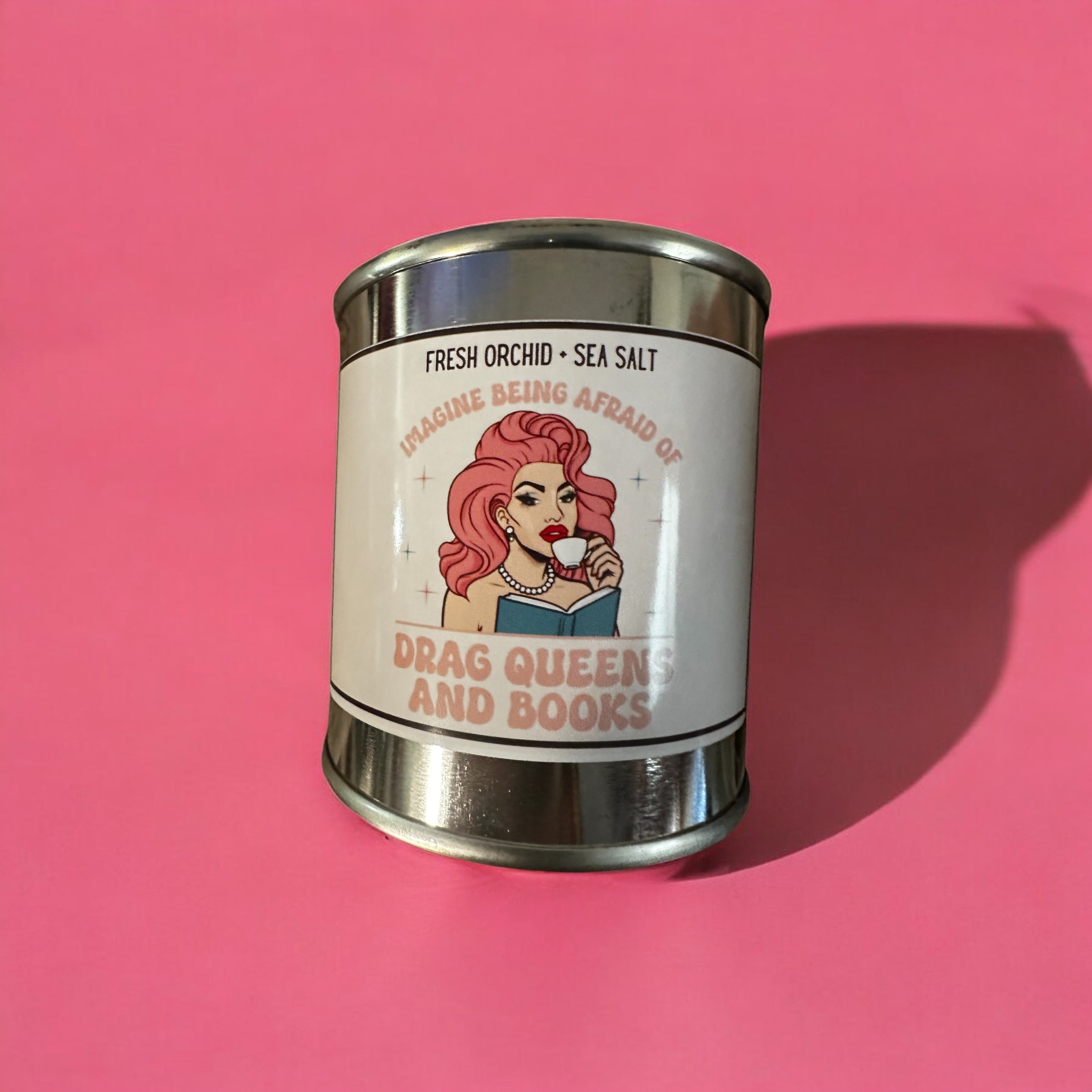 Candle in a paint can with a graphic of a drag queen and text on a pink background